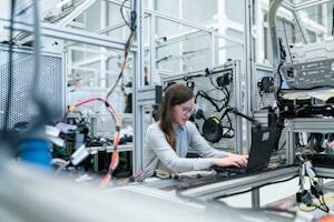 Engineer reviewing a digital model on a laptop inside a modular factory